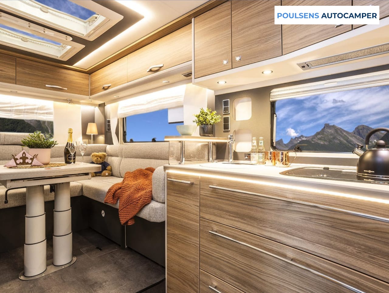 Salon intérieur du camping-car intégré Dethleffs ALPA I 6820-2 2025 avec banquettes confortables et table centrale
