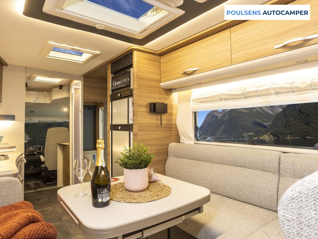 Salon intérieur du camping-car intégré Dethleffs ALPA I 6820-2 2025 avec banquettes confortables et table centrale