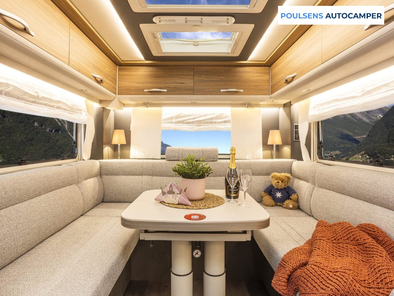 Salon intérieur du camping-car intégré Dethleffs ALPA I 6820-2 2025 avec banquettes confortables et table centrale